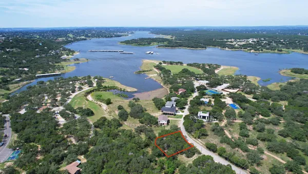 an aerial view of a residential houses with outdoor space and trees