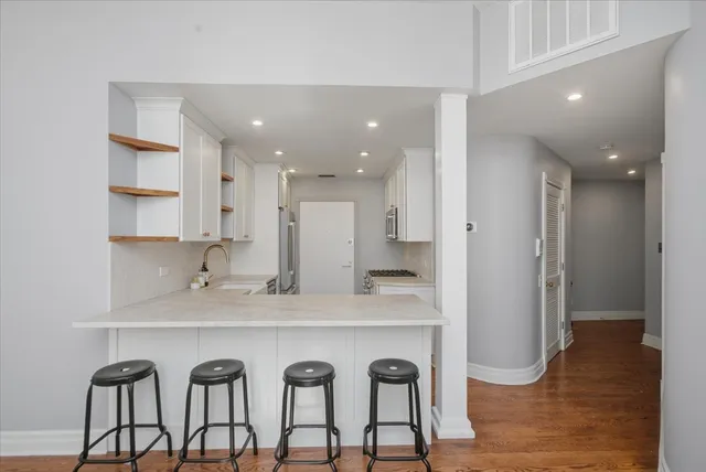 a large kitchen with granite countertop a table chairs sink and cabinets
