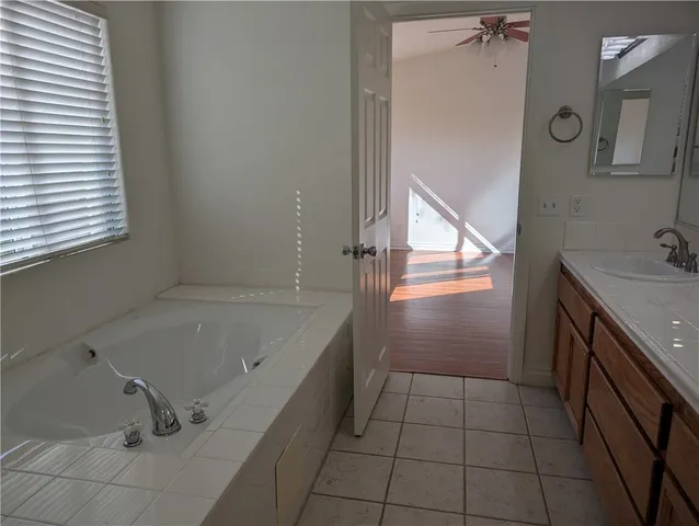 a bathroom with a tub sink and mirror
