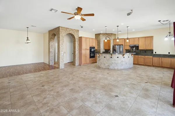 a large kitchen with kitchen island granite countertop a stove refrigerator and cabinets