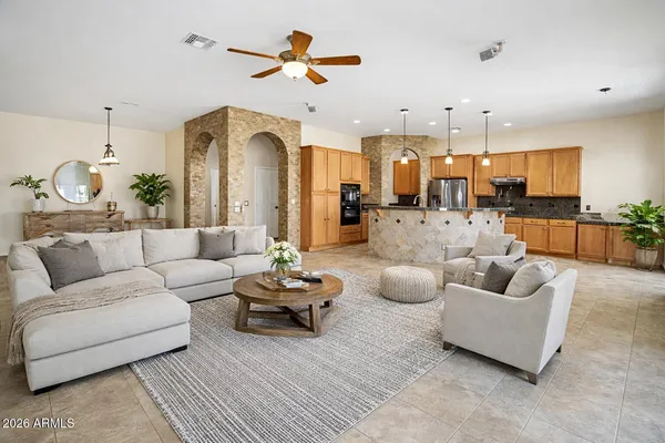 a living room with furniture kitchen view and a chandelier