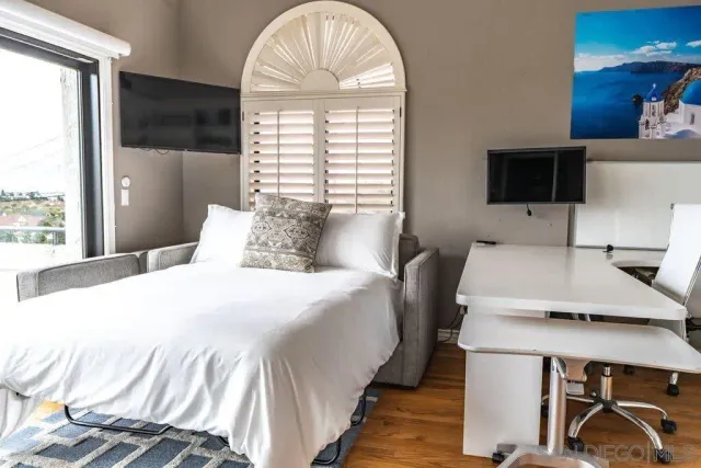 a bedroom with a bed and a large window