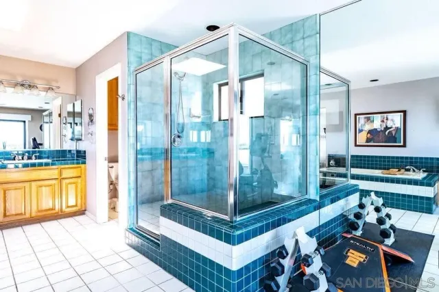 a bathroom with a tub shower and mirror