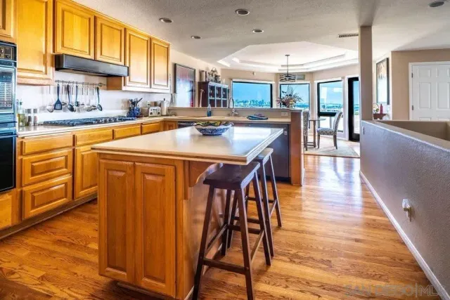 a view of a dining room and livingroom with furniture wooden floor a chandelier
