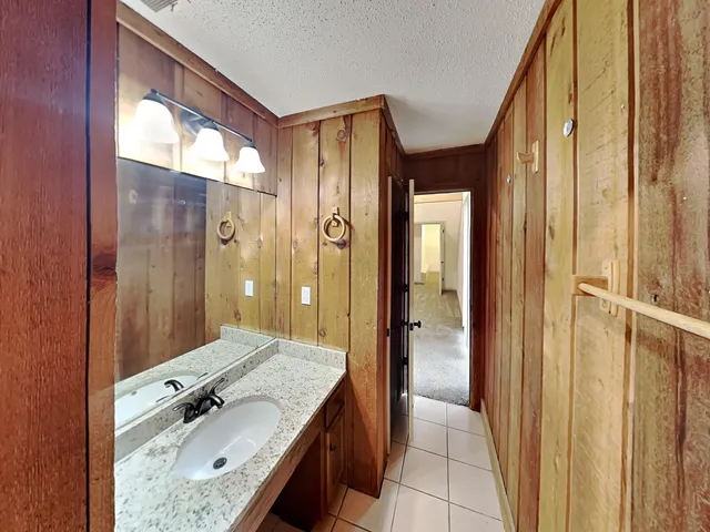 a view of an empty room and chandelier fan
