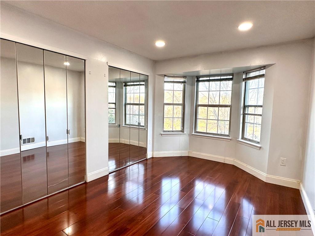 341 Wimbeldon Court North Brunswick, NJ 08902 - Photo 5 of 14 wooden floor in an empty room with a window