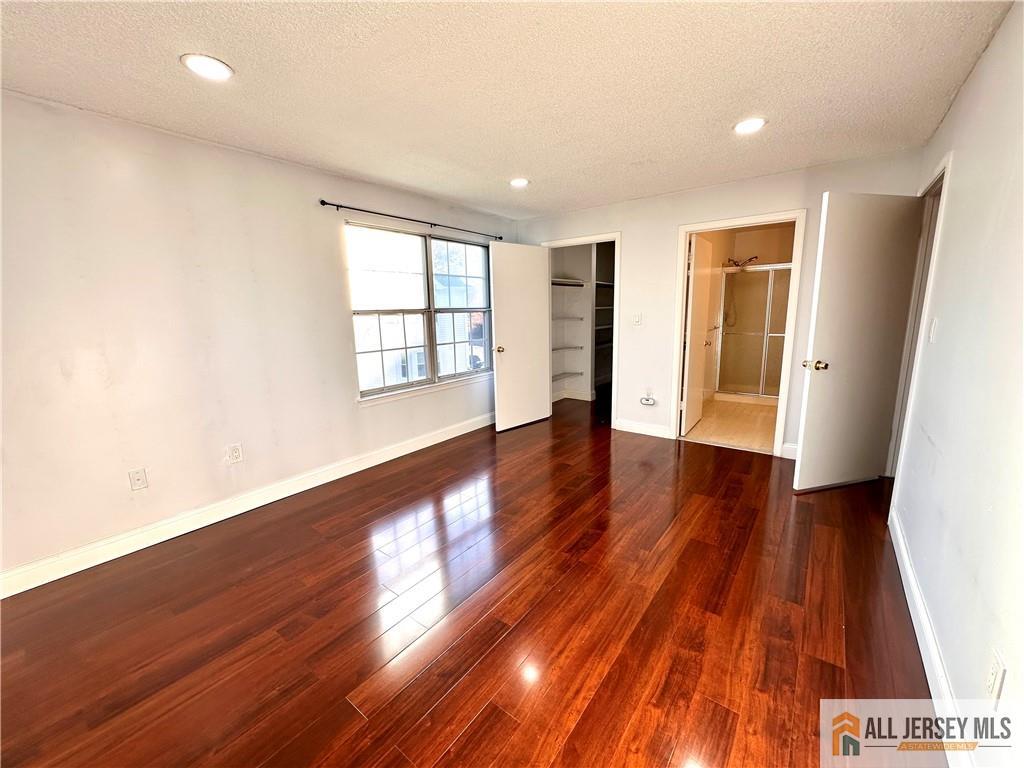 341 Wimbeldon Court North Brunswick, NJ 08902 - Photo 7 of 14 a view of an empty room with wooden floor and a window