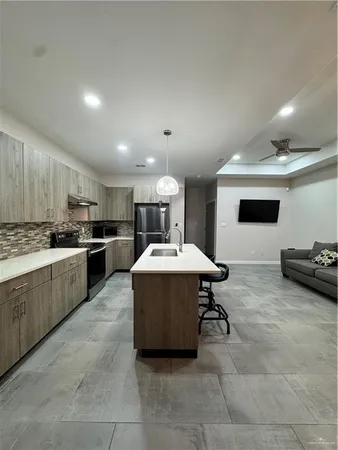 a kitchen with a sink a counter top space and stainless steel appliances