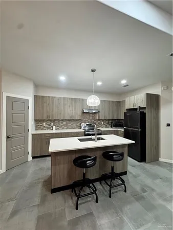 a kitchen with a sink a counter top stainless steel appliances and cabinets