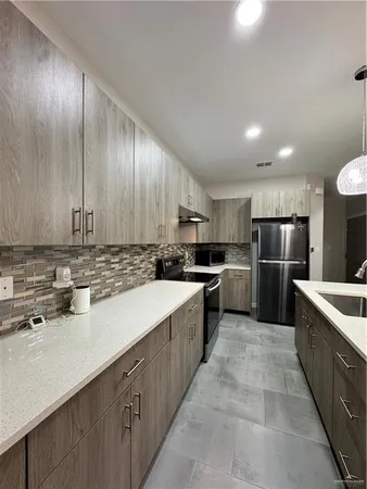 a kitchen with stainless steel appliances granite countertop a sink counter space cabinets and a large window