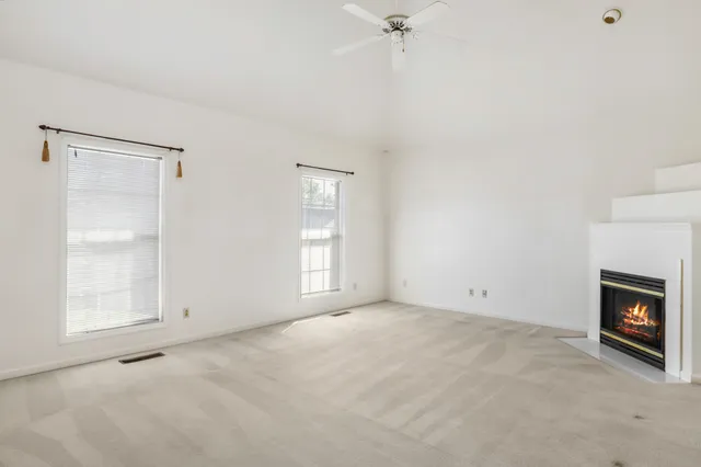 a view of an empty room with a fireplace and a window