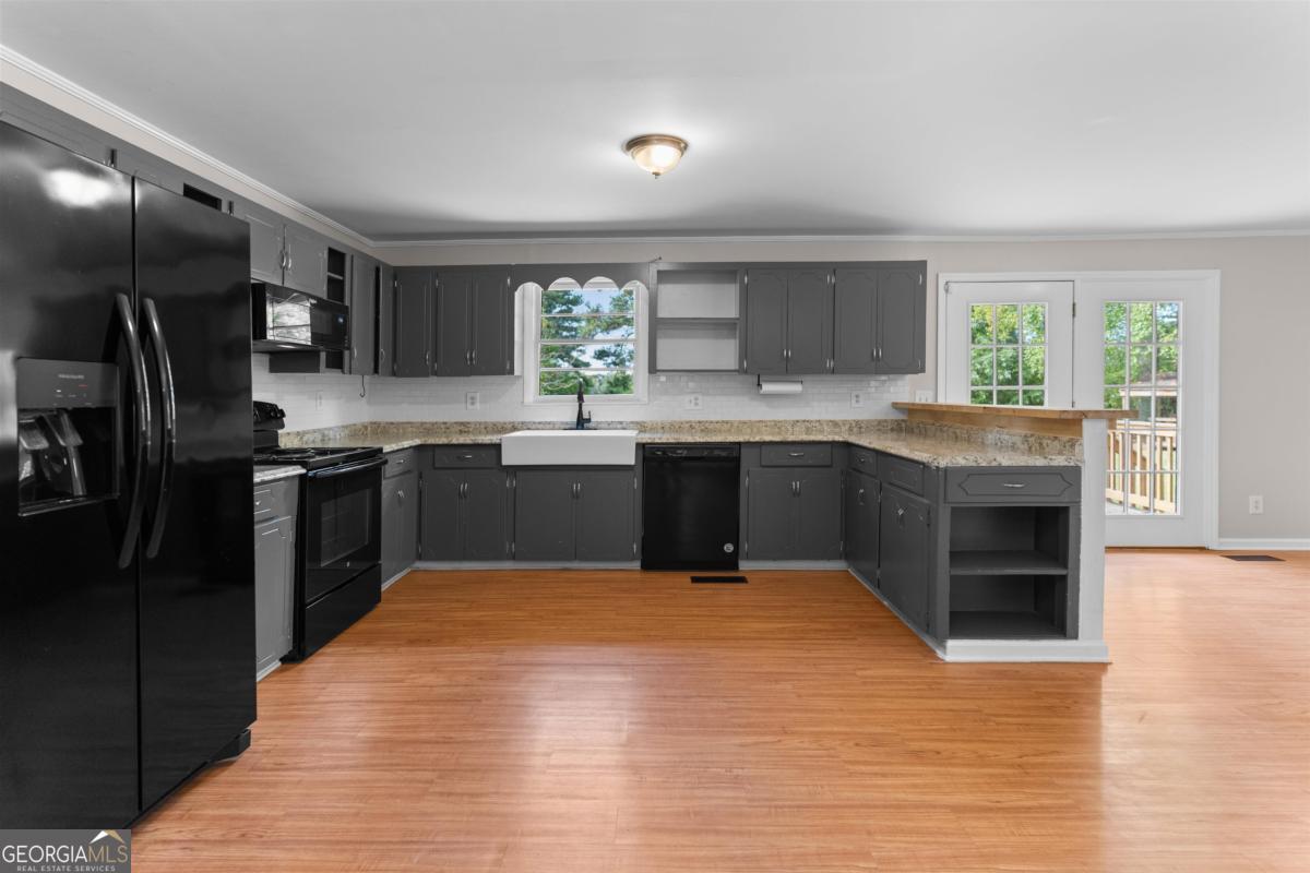 1251 Brickhouse Road Greensboro, GA 30642 - Photo 11 of 35 a large kitchen with stainless steel appliances granite countertop a stove sink and cabinets