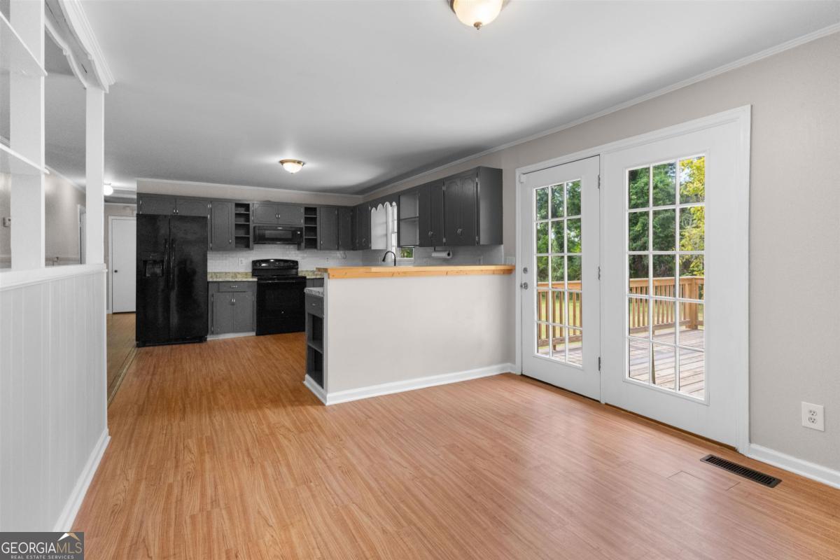 1251 Brickhouse Road Greensboro, GA 30642 - Photo 13 of 35 a kitchen with stainless steel appliances kitchen island wooden floors and refrigerator