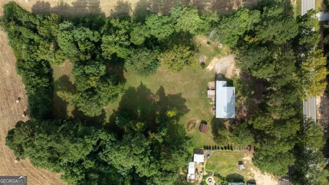 an aerial view of residential houses with outdoor space and trees