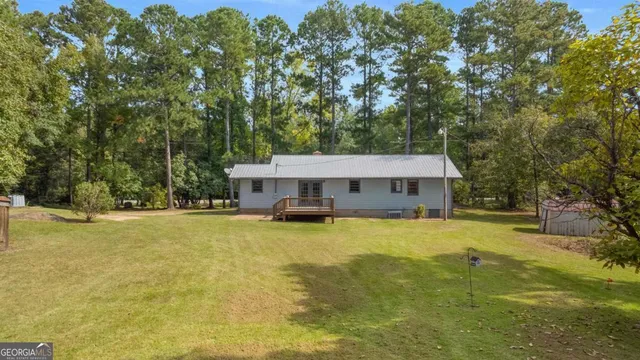 a view of a house with pool and sitting area