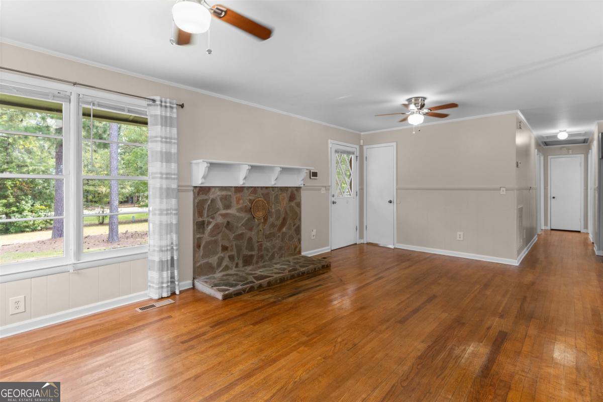 1251 Brickhouse Road Greensboro, GA 30642 - Photo 8 of 35 a view of empty room with wooden floor and fan