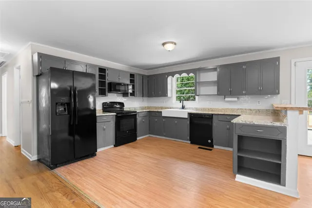 a kitchen with granite countertop stainless steel appliances cabinets a sink and a window