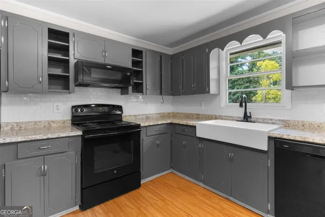 a kitchen with kitchen island granite countertop a sink stainless steel appliances and cabinets