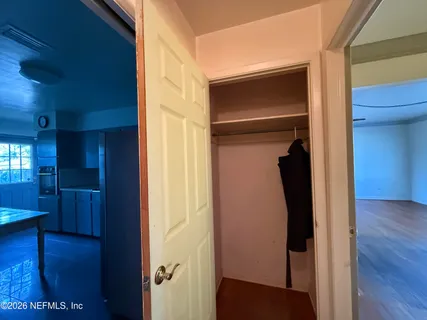a view of a hallway with wooden floor and closet