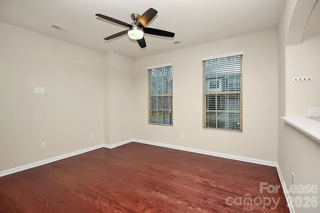 a view of a big room with wooden floor and windows