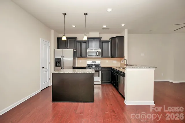 a kitchen with stainless steel appliances granite countertop a stove top oven a sink and a granite counter top