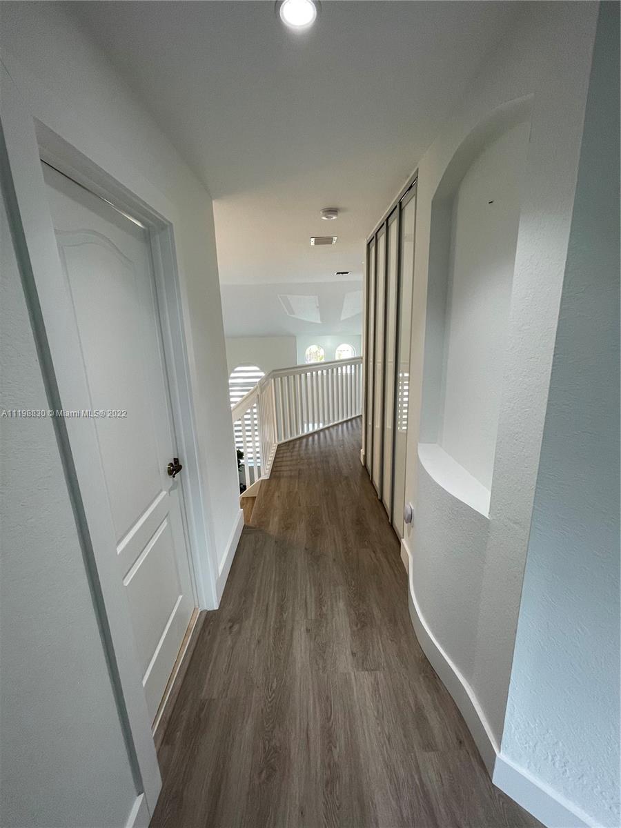 Doral Isles Doral, FL 33178 - Photo 21 of 35 a view of a hallway with wooden floor and staircase