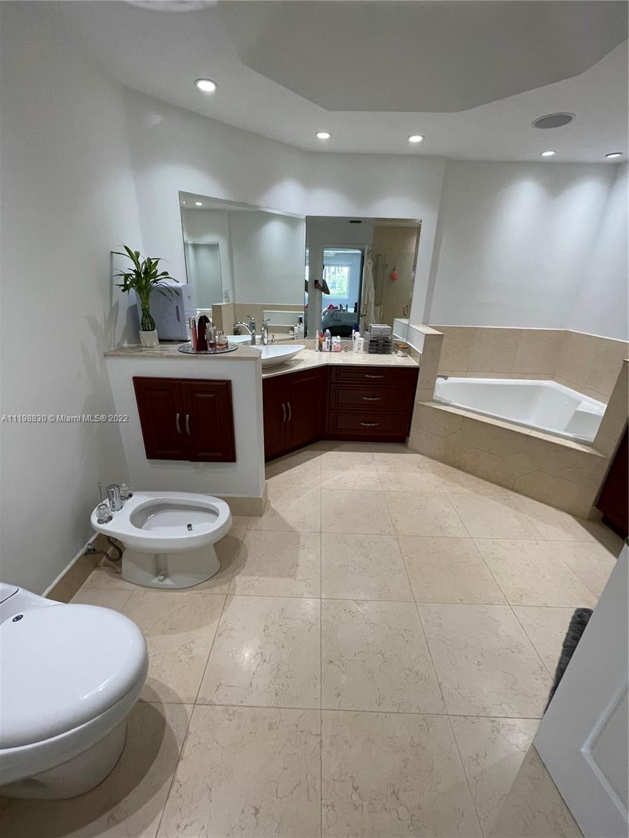 Doral Isles Doral, FL 33178 - Photo 24 of 35 a bathroom with a toilet sink and mirror