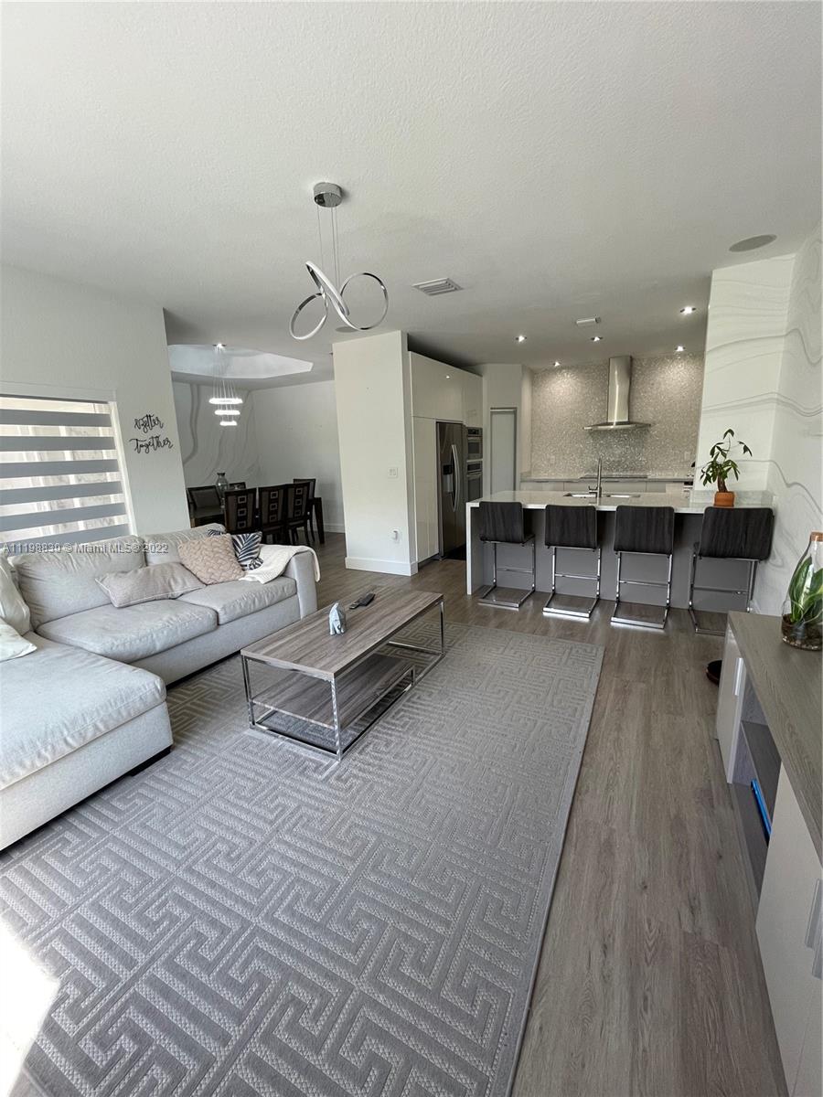 Doral Isles Doral, FL 33178 - Photo 10 of 35 a living room with furniture and a wooden floor