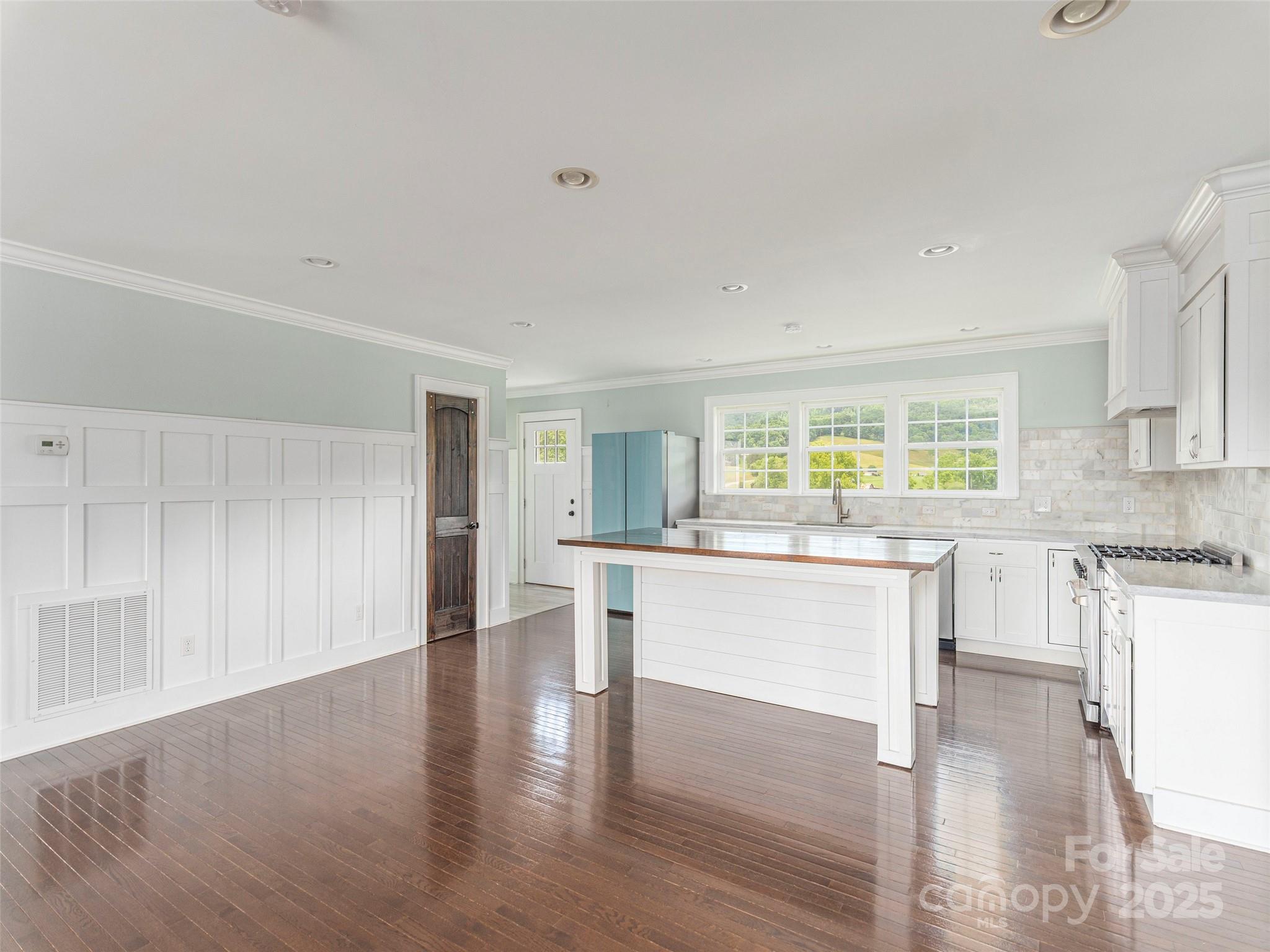 3355 Thickety Road Clyde, NC 28721 - Photo 5 of 33 a kitchen with white cabinets and wooden floor
