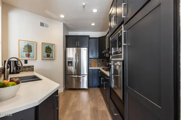 a kitchen with kitchen island a sink appliances and cabinets