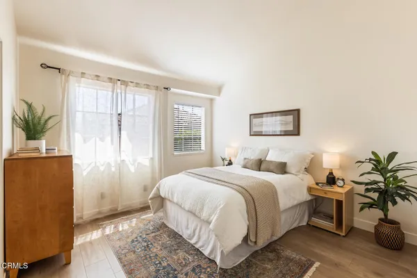 a bedroom with a bed lamp and a potted plant