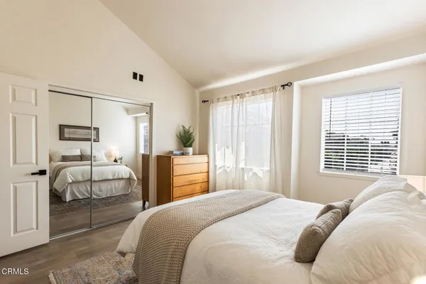 a bedroom with a large bed and wooden floor