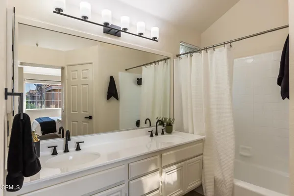 a bathroom with a double vanity sink and a mirror