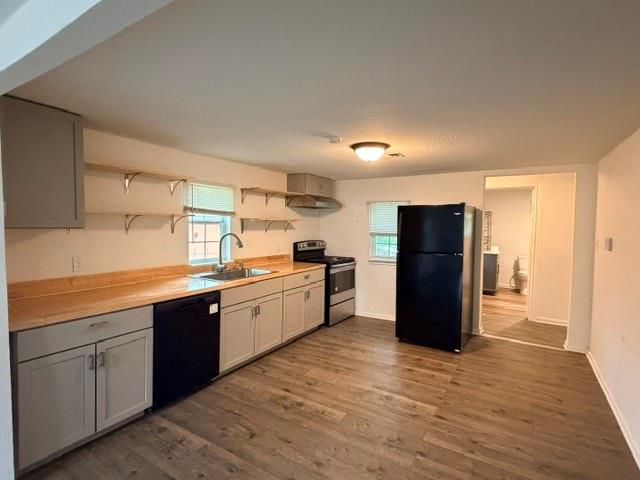 927 West Baker Street Denison, TX 75020 - Photo 3 of 14 a large kitchen with a refrigerator and a stove top oven