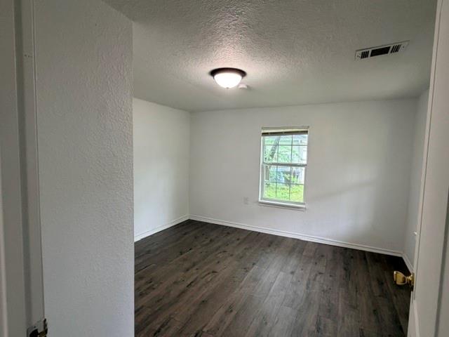 927 West Baker Street Denison, TX 75020 - Photo 9 of 14 an empty room with wooden floor and windows