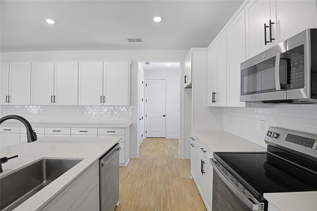 3725 Deer Rdg Drive Mount Dora, FL 32757 - Photo 7 of 23 a kitchen with stainless steel appliances a sink stove and cabinets