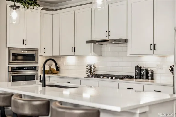 a kitchen with stainless steel appliances granite countertop a sink a stove and refrigerator