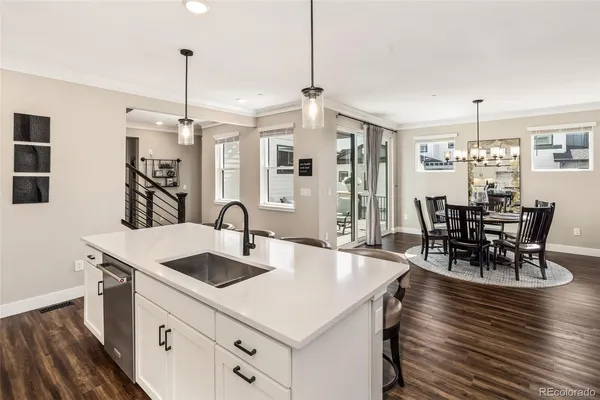 a open kitchen with stainless steel appliances granite countertop a kitchen island a stove a table and chairs