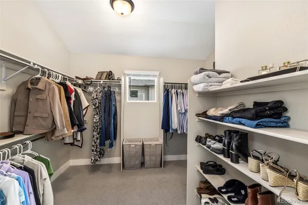 a view of walk in closet with clothes and shoes