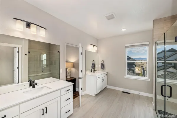 a spacious bathroom with a double vanity sink a mirror and a bathtub
