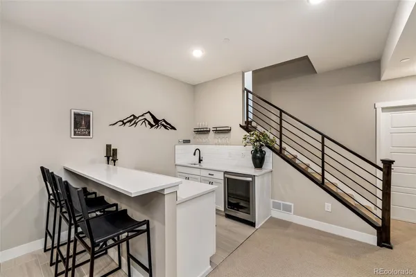 a kitchen with a sink a stove and chairs
