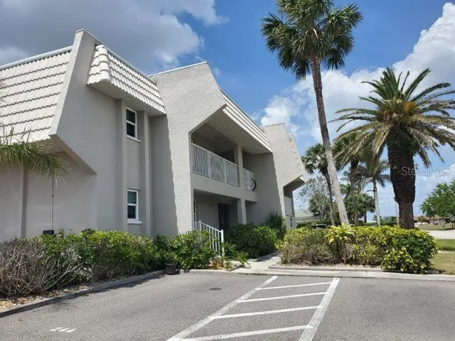 a front view of multi story residential apartment building with yard and entryway