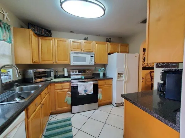 a kitchen with stainless steel appliances granite countertop a refrigerator a stove top oven a sink and dishwasher