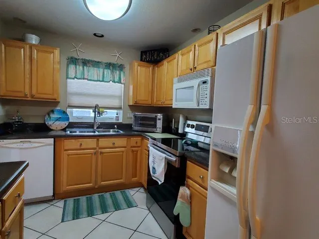 a kitchen with stainless steel appliances granite countertop sink stove refrigerator and cabinets