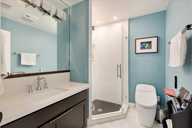 a bathroom with a sink vanity mirror and toilet