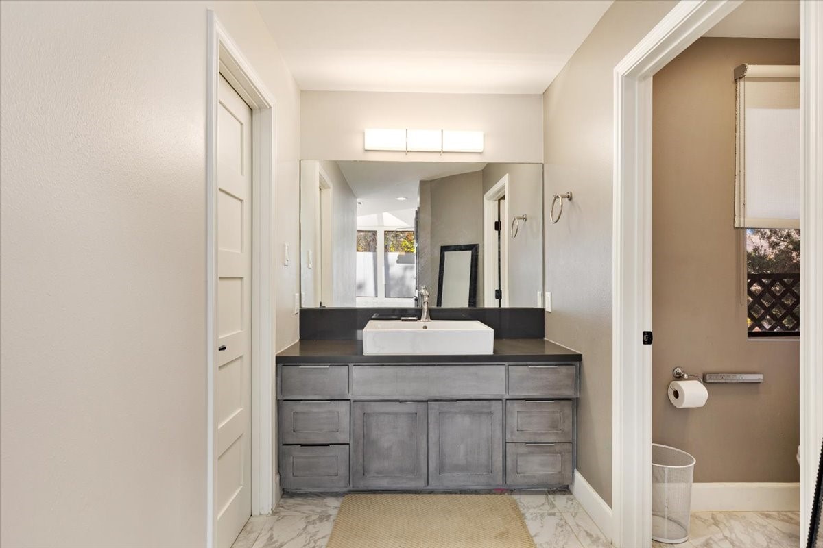 201 Vanderpool Lane, Unit 130 Houston, TX 77024 - Photo 16 of 23 a en suite bathroom with a granite countertop sink and a mirror