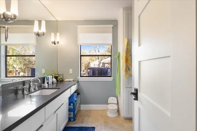 a bathroom with a granite countertop sink toilet and shower