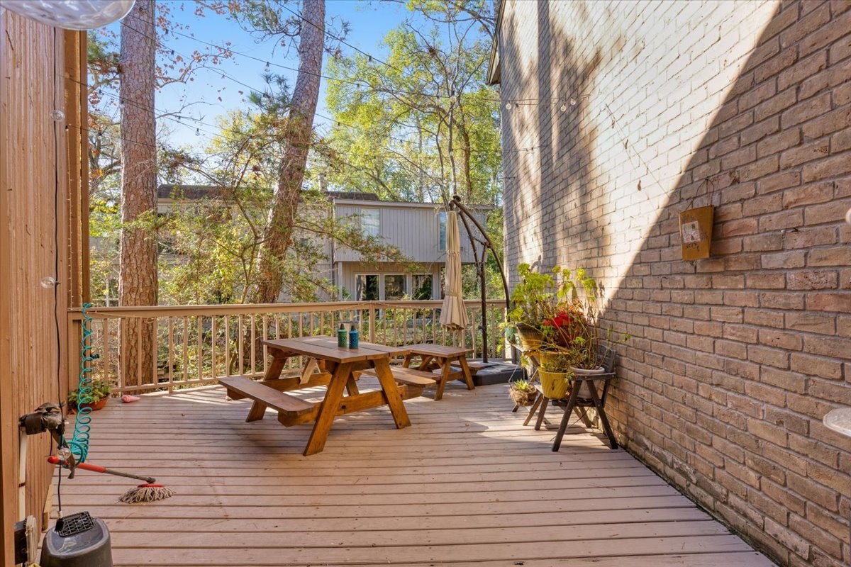 201 Vanderpool Lane, Unit 130 Houston, TX 77024 - Photo 20 of 23 a balcony with wooden floor table and chairs