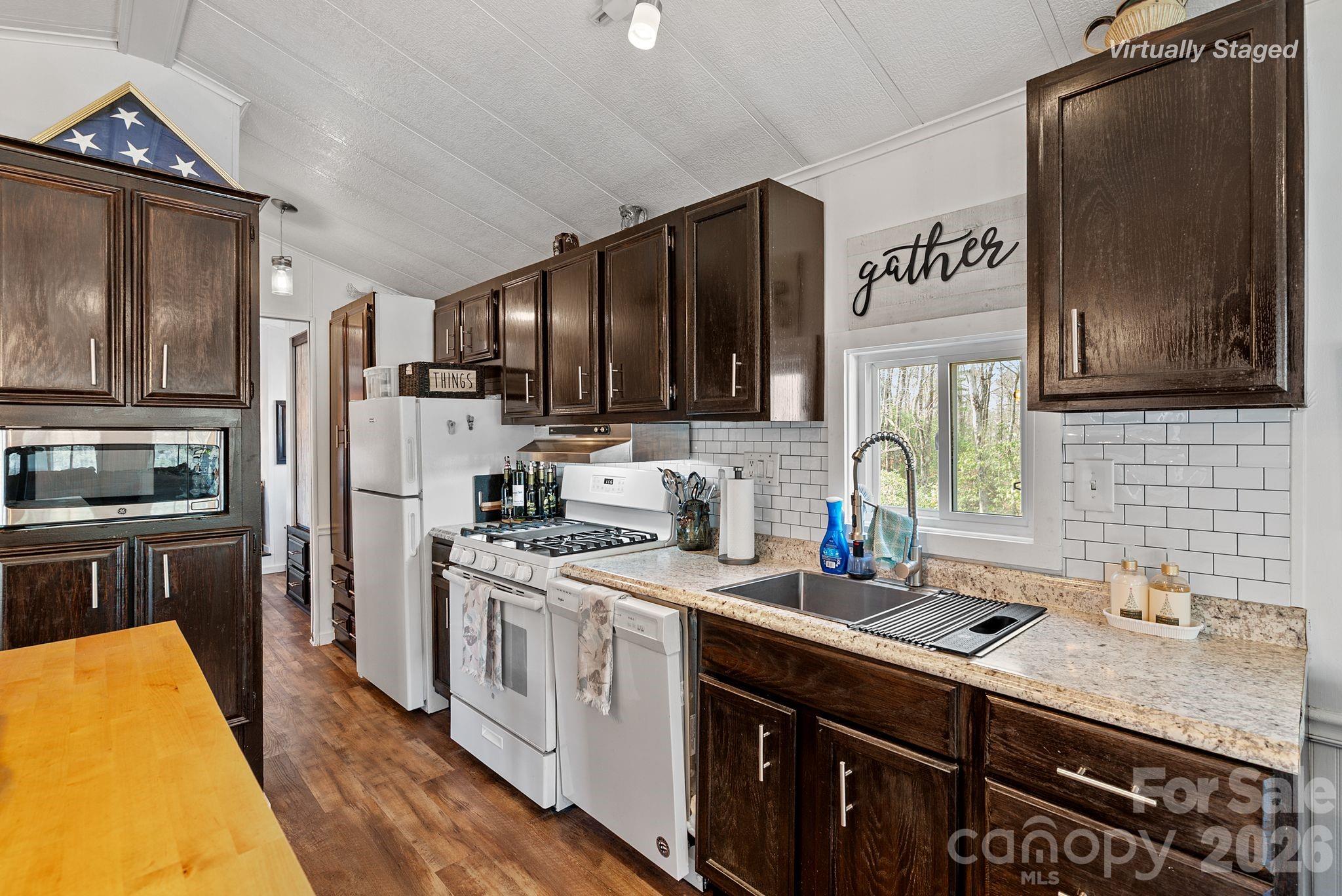 54 South Kimiko Lane Balsam Grove, NC 28708 - Photo 21 of 46 a kitchen with stainless steel appliances a sink cabinets and wooden floor