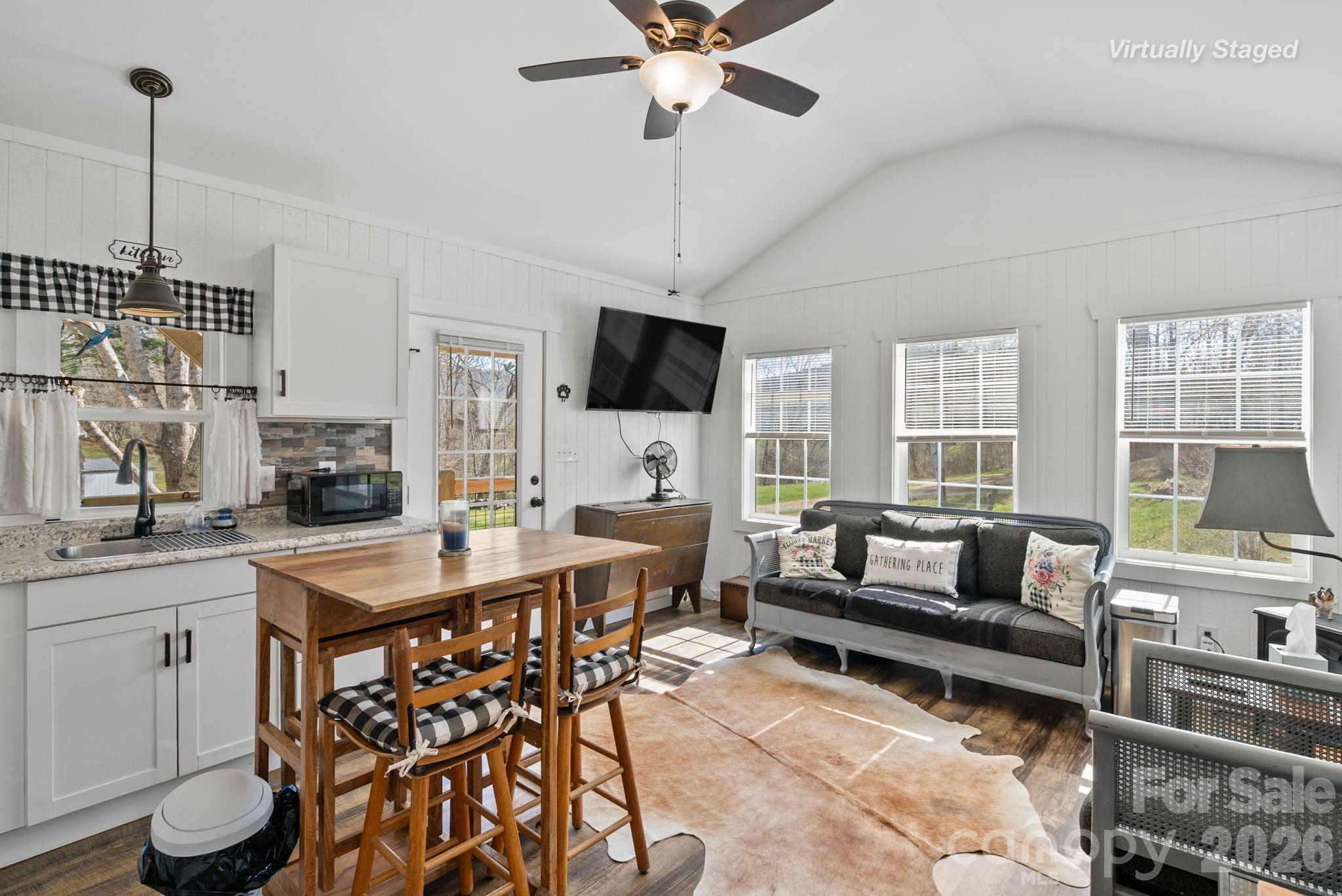 54 South Kimiko Lane Balsam Grove, NC 28708 - Photo 5 of 46 a kitchen with a stove a sink dishwasher a dining table and chairs with wooden floor